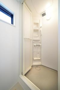 a small white bathroom with a shower and a window at SENKO TINY CAMP - Vacation STAY 34705v in Ueda