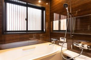 ein Badezimmer mit Badewanne und Fenster in der Unterkunft Private resort Hibiki no Yado & Mori - Vacation STAY 38605v in Sato-moriya
