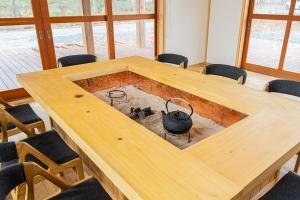 ein Konferenzraum mit einem großen Holztisch und Stühlen in der Unterkunft Private resort Hibiki no Yado & Mori - Vacation STAY 38605v in Sato-moriya