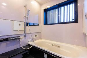 ein Badezimmer mit Badewanne und Fenster in der Unterkunft Private resort Hibiki no Yado & Mori - Vacation STAY 85305v in Sato-moriya