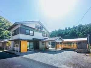 a white house with a wooden fence in front of it at Goenza OYADO - Vacation STAY 86977v in Takinohai