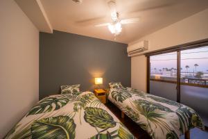 zwei Betten in einem Zimmer mit Fenster in der Unterkunft Heritage 21 - Vacation STAY 14227 in Beppu
