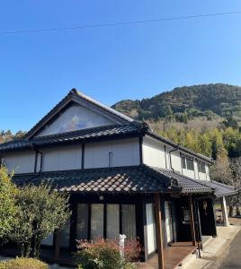 ein Gebäude mit einem Berg im Hintergrund in der Unterkunft Kominka BASE Ryuo - Vacation STAY 87634v in Usa