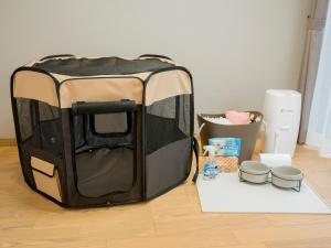 eine schwarz-braune Hundehütte auf dem Boden in der Unterkunft Rakuten STAY VILLA Yatsugatake - 104 Family Room Pets Friendly - in Hokuto