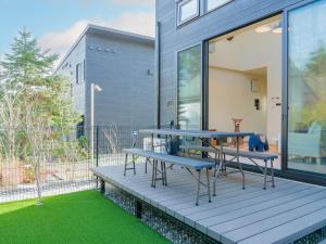 eine Terrasse mit einem Tisch und Bänken darauf in der Unterkunft Rakuten STAY VILLA Yatsugatake - 104 Family Room Pets Friendly - in Hokuto + 52 Fotos