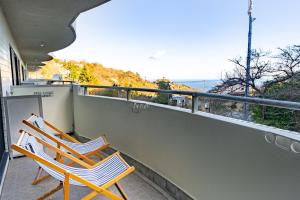 two chairs on a balcony with a view of the ocean at VIVI Atami Shizenkyo Room 3001 - Vacation STAY 14277 in Atami