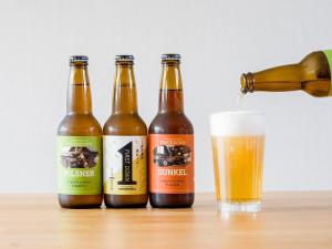 four bottles of beer sitting on a table with a beer at Rakuten STAY VILLA Yatsugatake - 108 Simple Modern Pets Friendly - in Hokuto