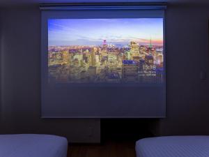 a flat screen tv in a bedroom with a city at Rakuten STAY VILLA Yatsugatake - 108 Simple Modern Pets Friendly - in Hokuto