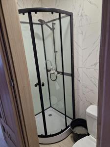 a shower with a glass door in a bathroom at Trumpalaike nuoma in Kelmė