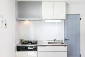 a white kitchen with white cabinets and a sink at Kunigamigun - House - Vacation STAY 90967v in Amesoko