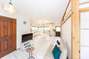 a living room with a couch and a tv at Ａｗａｊｉ Ｓｅａｓｉｄｅ Ｖｉｌｌａ ｉｎ Ｇｏｓｈｉｋｉ - Vacation STAY 98416v in Sumoto