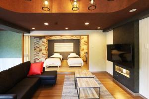 ein Wohnzimmer mit einem Sofa und 4 Betten in der Unterkunft Lions Mansion Sapporo Jozankei Sanbankan Room 201 - Vacation STAY 14335 in Jozankei + 37 Fotos