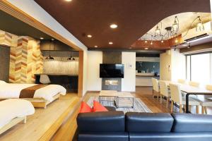 ein Schlafzimmer mit einem Sofa und einem Bett sowie ein Esszimmer in der Unterkunft Lions Mansion Sapporo Jozankei Sanbankan Room 201 - Vacation STAY 14335 in Jozankei