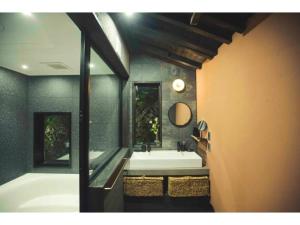 a bathroom with a tub and a sink and a mirror at Hyogo private house yogoto - Vacation STAY 00235v in Kamikawa