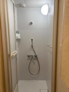 a shower with a hose in a white bathroom at Populus-club Otaru - Vacation STAY 93434v in Otaru