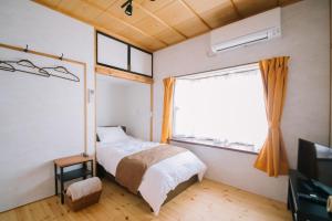 un dormitorio con una cama y una ventana en Sun Terrace Bessho Onsen - Vacation STAY 21387v, en Ueda