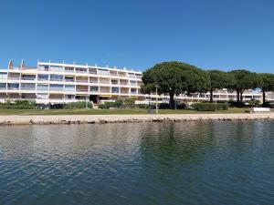 un grand immeuble situé à côté d'une étendue d'eau dans l'établissement Studio à deux pas de la mer, au Grau-du-Roi
