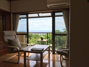a living room with a table and chairs and a large window at Masaya Villa - Vacation STAY 23215v in Ito