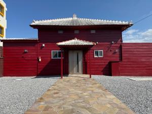 a red building with a red door and a tile roof at Aizanso - Vacation STAY 22208v in Nakijin