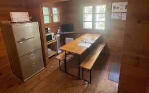 a kitchen with a wooden table and a refrigerator at village yumigahama - Vacation STAY 49340v in Minato