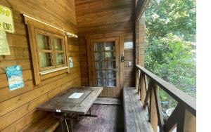a porch of a wooden cabin with a wooden table at village yumigahama - Vacation STAY 49340v in Minato