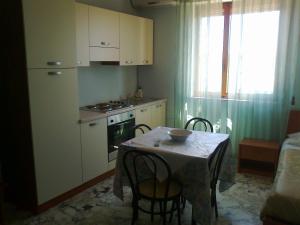 uma cozinha com mesa e cadeiras e uma cozinha com fogão em Hotel L'Approdo em Brindisi