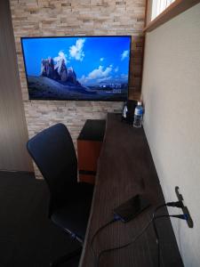 a room with a desk and a television on a wall at ＳＴＡＹ ＶＩＬＬＡ ＴＯＢＥＴＳＵ - Vacation STAY 14496 in Tōbetsu