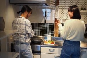 two women standing in a kitchen preparing food at Okatei - Vacation STAY 35463v in Fuchisaki +23 photos