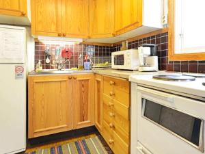 a kitchen with wooden cabinets and a white appliance at 4 person holiday home in Mönsterås-By Traum in Mönsterås