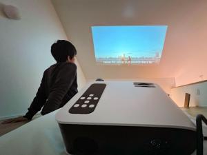 a young boy watching a television with a remote control at Beach SPA TSUDA"0 Cero house" - Vacation STAY 32935v in Sanuki