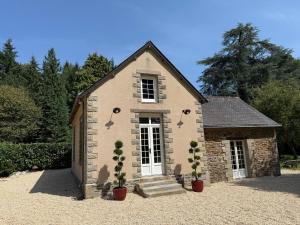 a stone house with two potted plants in front of it at House Nestled in the Forest in Vieux-Viel