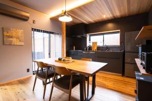 eine Küche und ein Esszimmer mit einem Holztisch und Stühlen in der Unterkunft simanoyadoya - Vacation STAY 85202v in Awaji