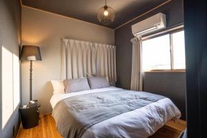 ein Schlafzimmer mit einem Bett und einem Fenster in der Unterkunft simanoyadoya - Vacation STAY 85202v in Awaji