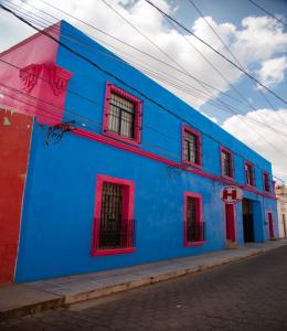 a blue building with red windows on a street at OYO Casa Vieja,Ciudad Serdán,Museo La Magnolia in Ciudad Serdán