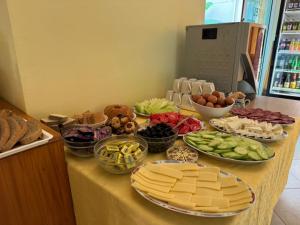 a table topped with plates of cheese and other foods at Хотел Грация in Lozenets