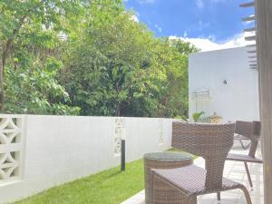 a patio with two chairs and a fence at kukulu island - Vacation STAY 37864v in Kouri
