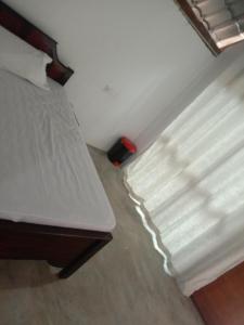 - une chambre avec un lit à côté d'une fenêtre dans l'établissement Rangiri Villa Sigiriya, à Dambulla 2 autres photos