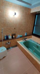 a bathroom with a green tub and a toilet at Unnoso - Vacation STAY 48299v in Kami-hiraya
