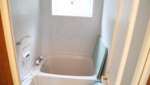 a bathroom with a bath tub and a window at Tabino Camping Base Kami Yuland - Vacation STAY 52574v in Osaki +2 photos
