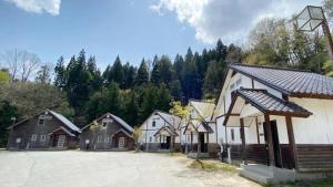 a group of houses in a row next to a parking lot at Tabino Camping Base Kami Yuland - Vacation STAY 52575v in Osaki