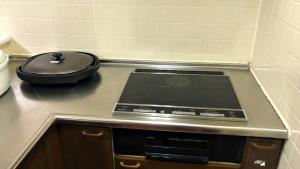 a kitchen counter with a stove with a lid on it at Tabino Camping Base Kami Yuland - Vacation STAY 52575v in Osaki