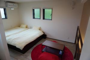 a small bedroom with two beds and a table at Kikunoko 3 Can Villa & Terrace C Building - Vacation STAY 50396v in Miyako Island