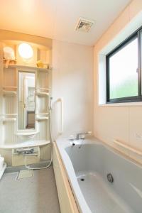 a bathroom with a tub and a sink and a window at Farm Inn Neba - Vacation STAY 42195v in Urugi