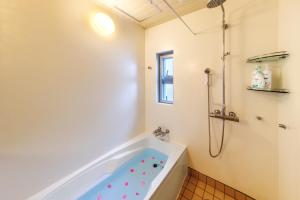a bathroom with a tub and a shower at New Life Mansion 101 - Vacation STAY 57160v in Fuzuchi +23 photos