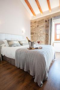 Un dormitorio con una cama grande con una pared de piedra. en A Cantaruxa Maruxa Turismo Rural, en Mondariz