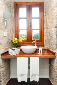 Un baño con lavabo y ventana. en A Cantaruxa Maruxa Turismo Rural, en Mondariz 37 fotos más