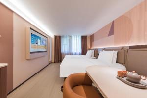 Ένα ή περισσότερα κρεβάτια σε δωμάτιο στο Orange Hotel Beijing West Railway Station South Square