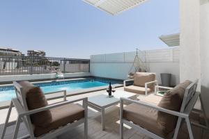 eine Terrasse mit Tisch und Stühlen und einem Pool in der Unterkunft ים סוף - דירת גן מושלמת עם בריכה פרטית למשפחות באילת in Eilat