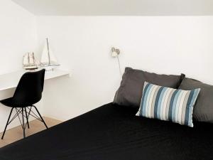 a bedroom with a bed with a chair and a desk at 5 star holiday home in Hadsund in Øster Hurup +39 photos