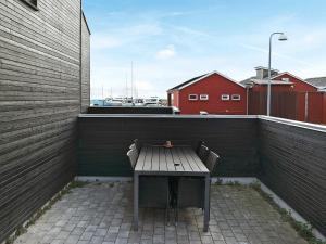 a wooden bench on a balcony with a table at 8 person holiday home in Hadsund-By Traum in Øster Hurup